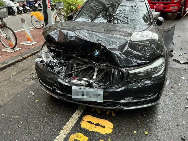 BMW遭推撞上人行道，撞到路樹後停下。翻攝畫面