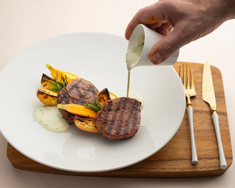 「炭烤頂級菲力牛排 燒烤洋芋藍紋起司醬」炭烤菲力與洋芋層疊排列，炭香、肉香與起司香相互交織。每道1250元。台北遠東香格里拉提供