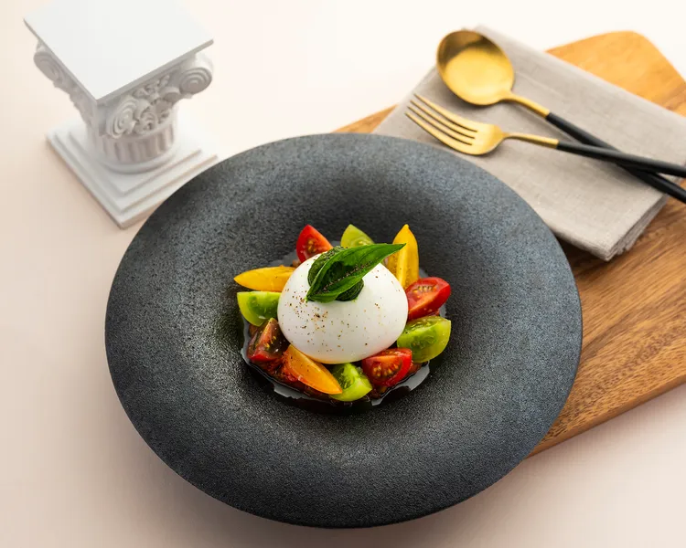 普利亞經典的「羅勒青醬 新鮮番茄塔塔 布拉塔起司」，以手工布拉塔與雙重番茄風味，加上清新的羅勒青醬，交織出自然純粹的南義風景。每道680元。台北遠東香格里拉提供 