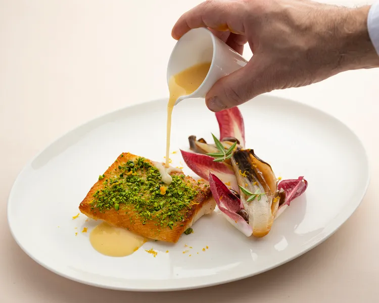 「炭烤深海比目魚 柑橘比利時菊苣 塔吉亞斯橄欖」以柑橘醬汁及塔吉亞斯橄欖提味的比目魚肉質鮮美細緻，滿滿的開心果碎增添口感。每道780元。台北遠東香格里拉提供