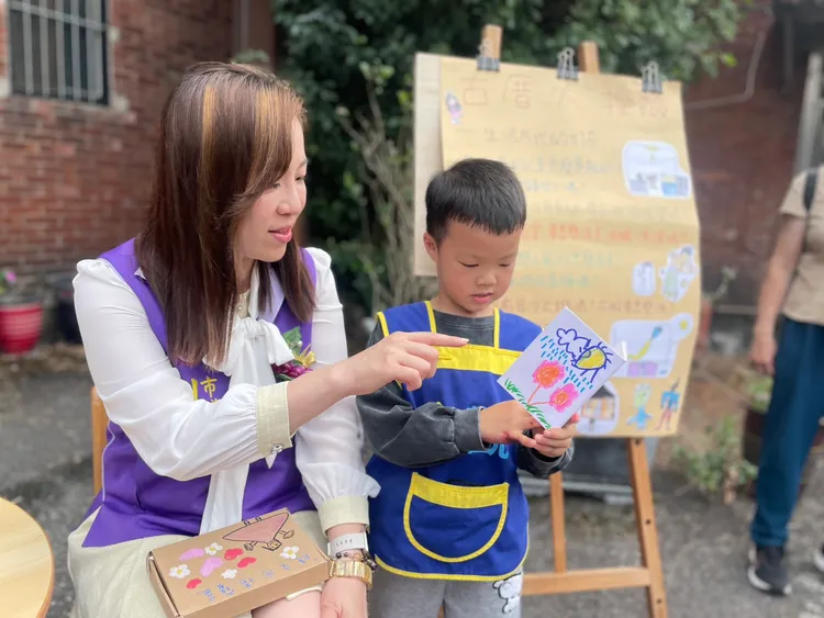 劉美芳陪同學童們的寫生活動，與孩子們一同描繪古厝景致。服務處提供