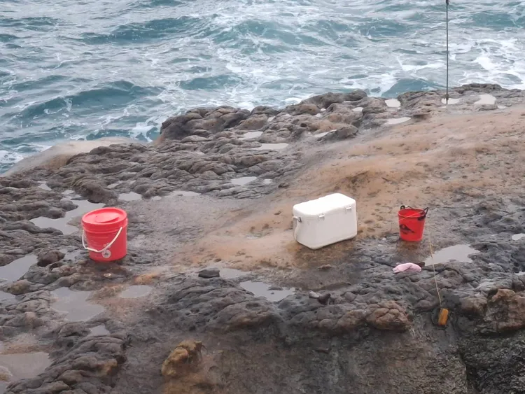 警方在海邊礁岩上找到陳男的釣魚用具。翻攝照片