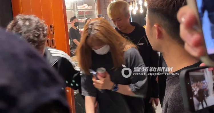 定延手拿鋁罐飲料，面對熱情的粉絲低頭坐上保母車離開。特勤中心攝