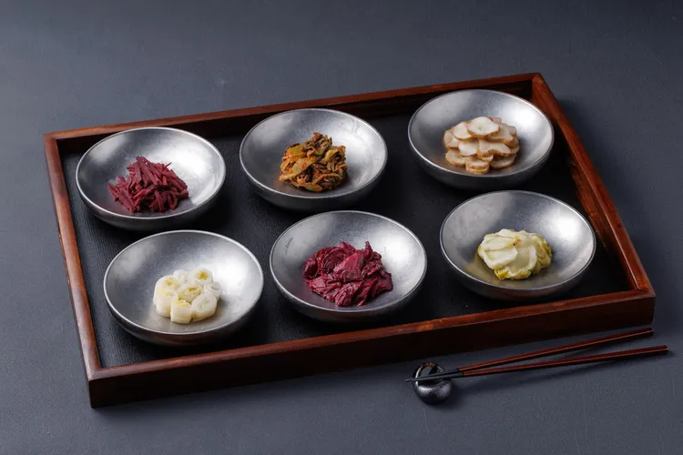 主廚每日準備多款自製泡菜，透過不同鹽漬與發酵手法呈現季節蔬菜風味。豊漁餐飲集團提供