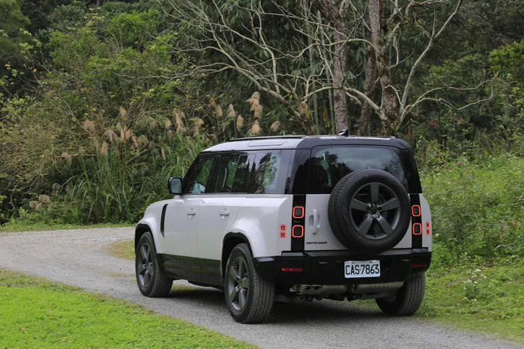 車尾設計延續Defender一貫的實用思維，側開式尾門與外掛備胎依然是最具代表性的元素。簡潔俐落的尾燈排列與筆直線條，讓整體看起來既粗獷又帶點機能美學。林浩昇攝