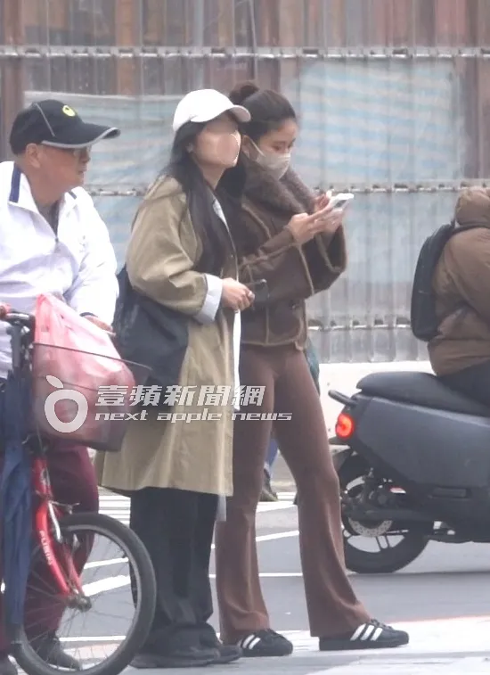 9m88（右）一邊滑手機一邊等候紅綠燈準備過馬路。特勤中心攝