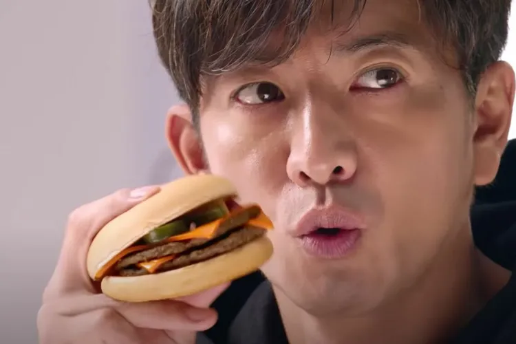 木村拓哉吃漢堡有自己獨特的拿法。翻攝麥當勞YT