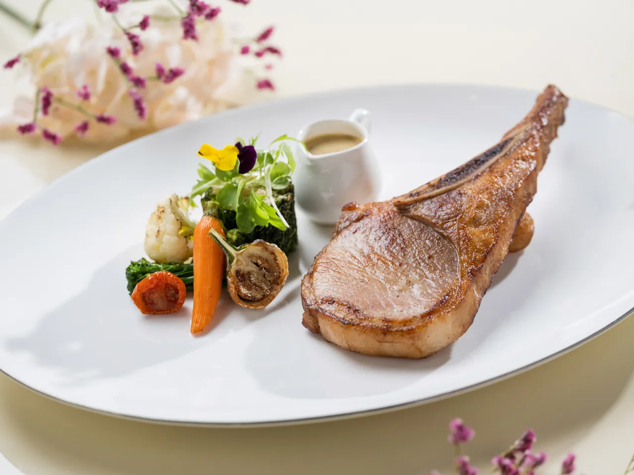 文華Café「平日午間饗．吃．吧」推出全新季節主餐「炙烤究好豬戰斧佐法式芥末醬」。台北文華東方酒店提供