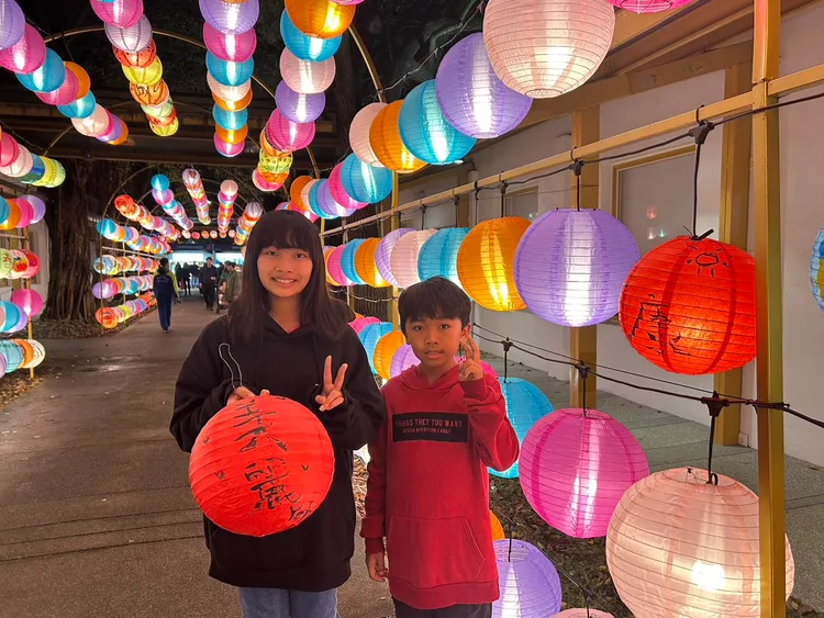 就讀國中和國小的姐弟提著舒華親筆簽名的燈籠。觀旅局提供