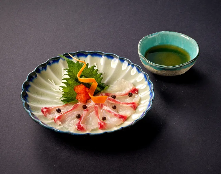 晴山日本料理春季饗宴由「鯛魚薄切」揭開序幕。主廚以細膩刀工片出透亮如玉的時令櫻鯛，點綴溫和的有馬山椒與香酸橙醋，在舌尖勾勒出大地復甦的清甜活力。台北美福大飯店提供