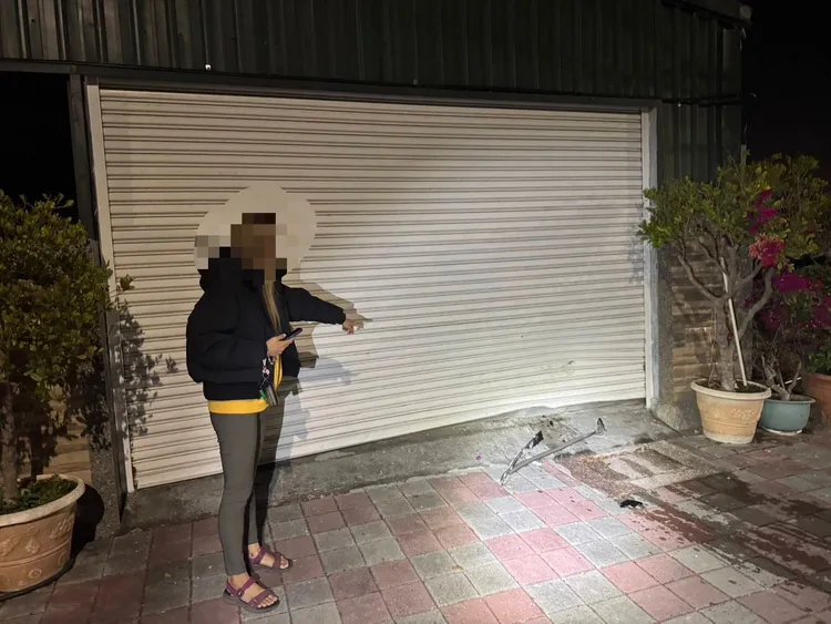 路旁民宅的鐵捲門也被撞凹。民眾提供