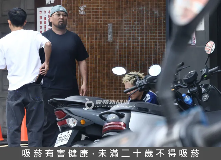 美麗本人（左）陪蹲在地上的春風抽加熱菸。特勤中心攝