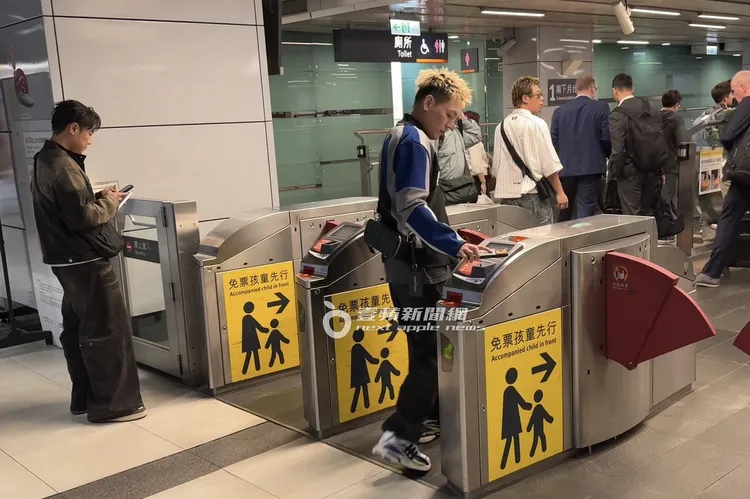 春風（右）順手掏出手機掃高鐵電子車票進站。特勤中心攝