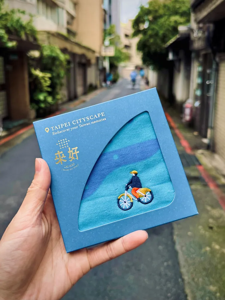 來好LAI HAO純棉手帕－U-bike款，以藍色調象徵城市與水岸交會，細緻刺繡描繪騎行者身影。純棉柔軟親膚，適合日常使用，也為生活留下一抹台北印象。台北凱撒大飯店提供
