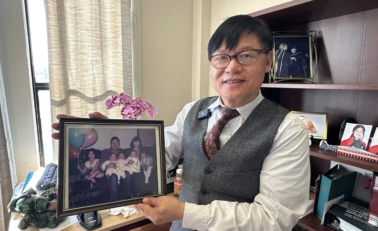 劉俊拿出全家福照片。中央社
