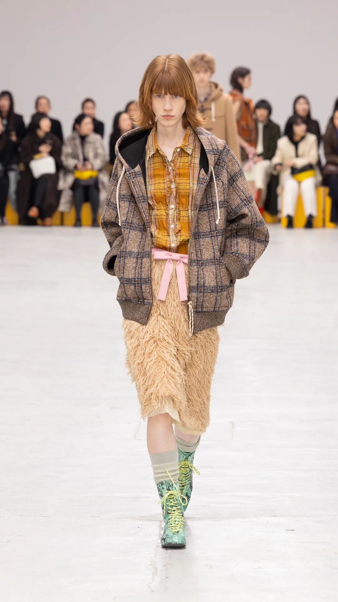 將格紋襯衫混搭具有羽毛質感的中長裙。品牌提供