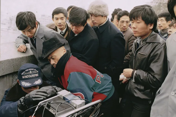 凌峰（前左二）與群眾圍觀監視器。財團法人民族文化教育基金會提供