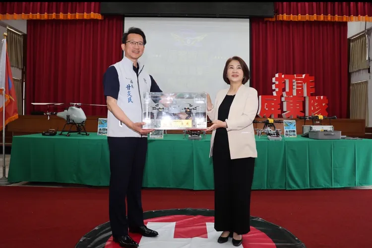 警察局長甘炎民致贈無人機模型給縣長周春米，感謝她持續推動科技建警。屏東縣警局提供