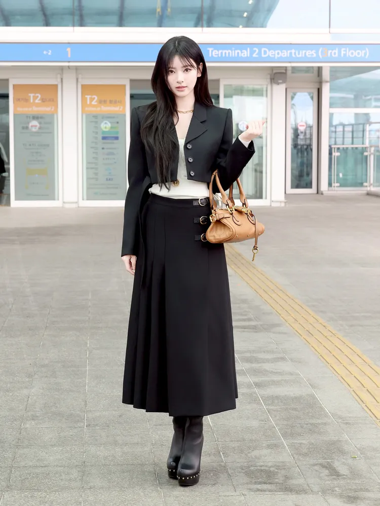 Anna機場選穿Chloé 2026早春系列的黑色短版羊毛西裝外套搭配褶襉中長裙。品牌提供