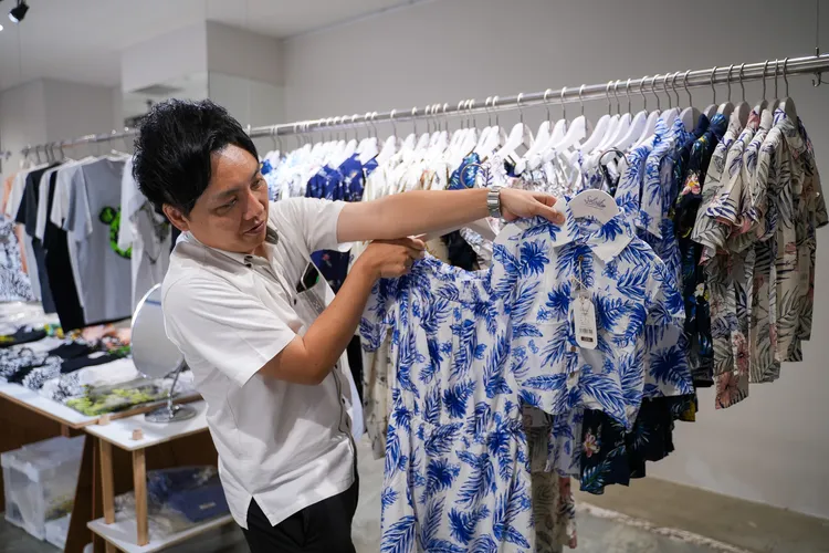 飯店負責人展示沖繩特有的「Kariyushi（かりゆし）」花襯衫。田欣雲攝