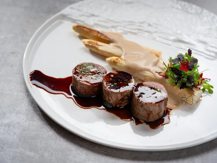 台北文華東方酒店「Bencotto」義大利餐廳推出季節限定白蘆筍佳餚「爐烤羊背脊鑲菠菜、炙烤白蘆筍、榛果醬、羊肉汁、香草沙拉」。台北文華東方酒店提供