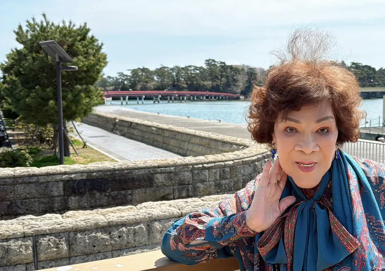 周遊身後紅色的長橋「福浦橋」是台灣人捐贈兩億元興建的。李朝永提供