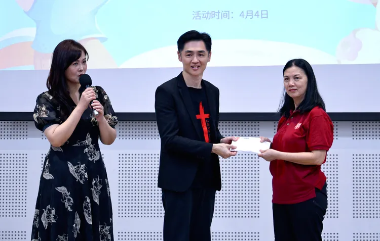 宋逸民（中）獻出一點心意給當地教會，左為陳維齡。藝起發光、蒙福教會提供 