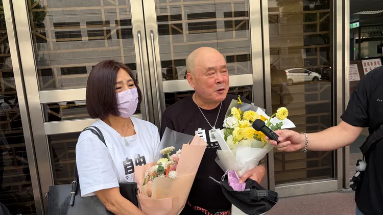 蘇耀輝與妻子接受冤平協會獻花。張欽攝