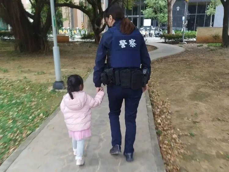 女警帶著女童在公園找尋家人。平鎮警分局提供