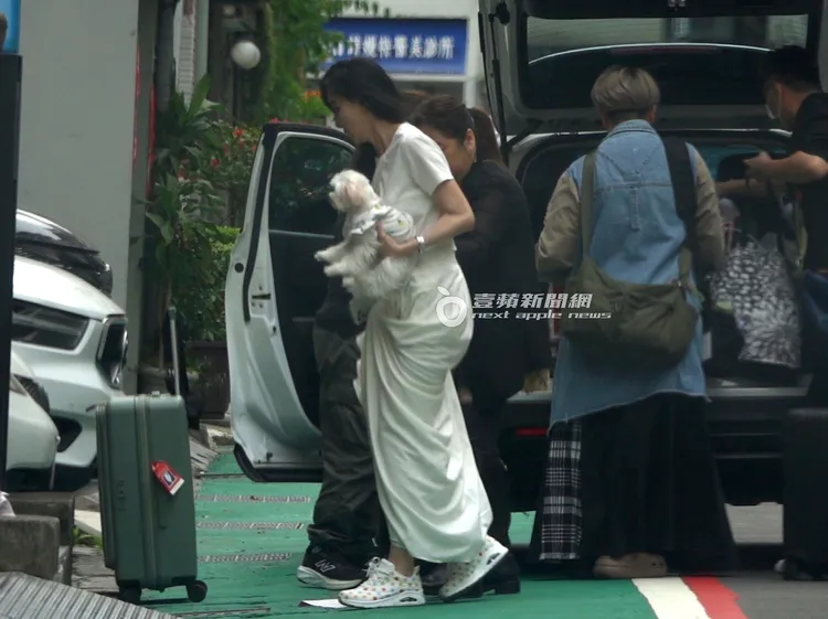 蕭薔（左）讓助理幫忙提裙子，走進工作室。特勤中心攝