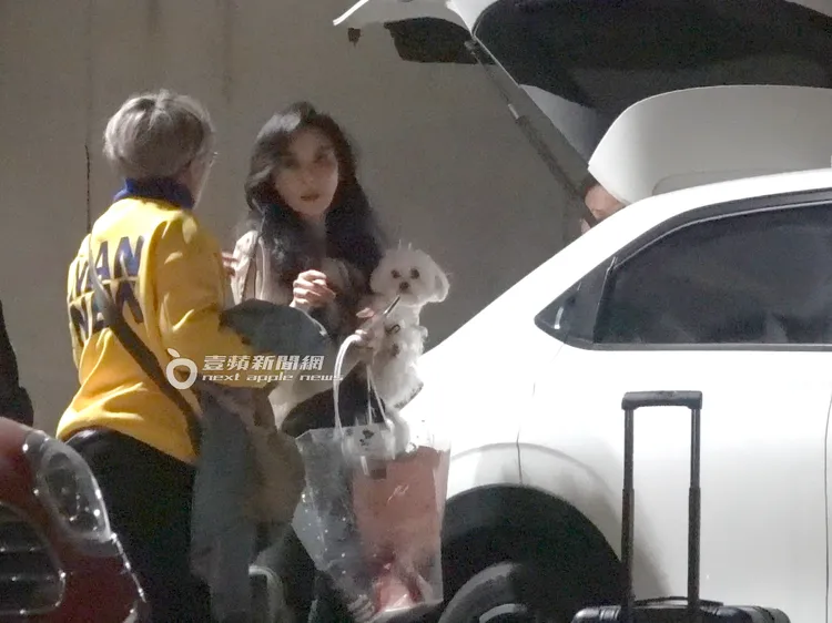 蕭薔抱著愛犬一手提著花束，準備坐上車離開。特勤中心攝