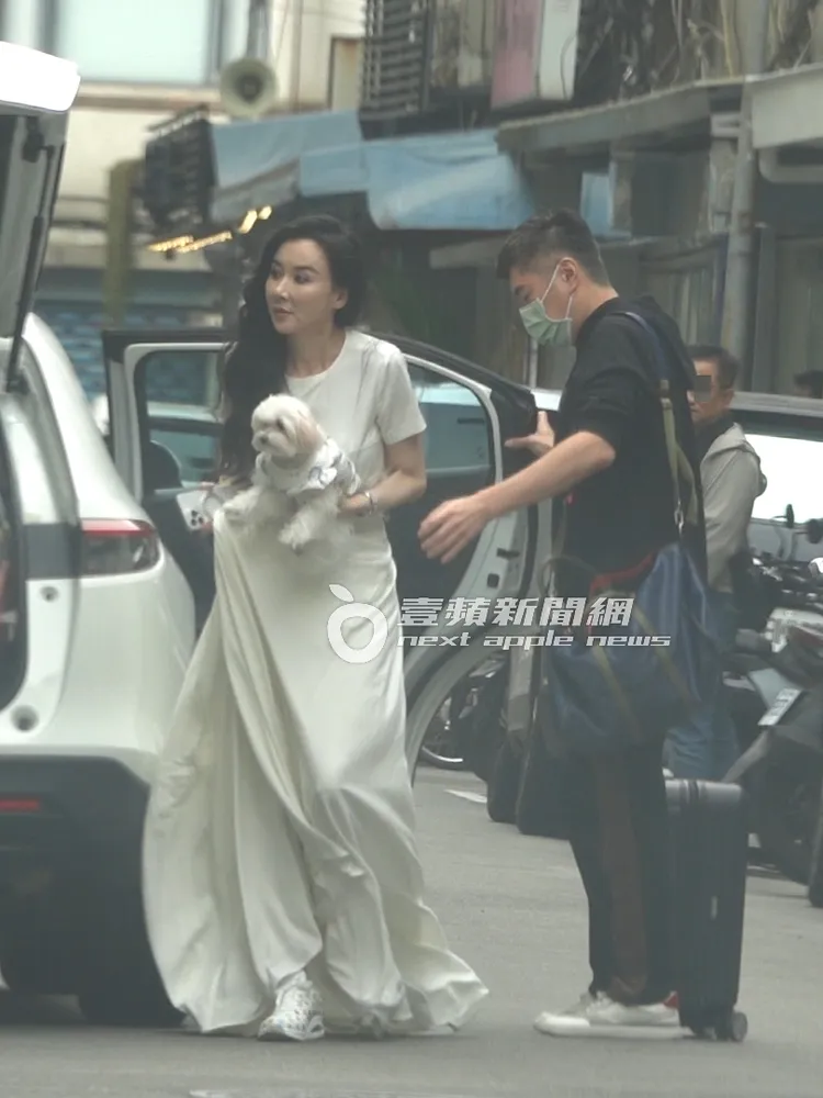 蕭薔抱著愛犬準備走進工作室，護花男關上車門。特勤中心攝