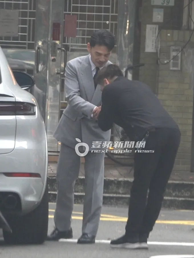 阿Ken（左）準備離開時，一旁保母車司機上前鞠躬打招呼。特勤中心攝