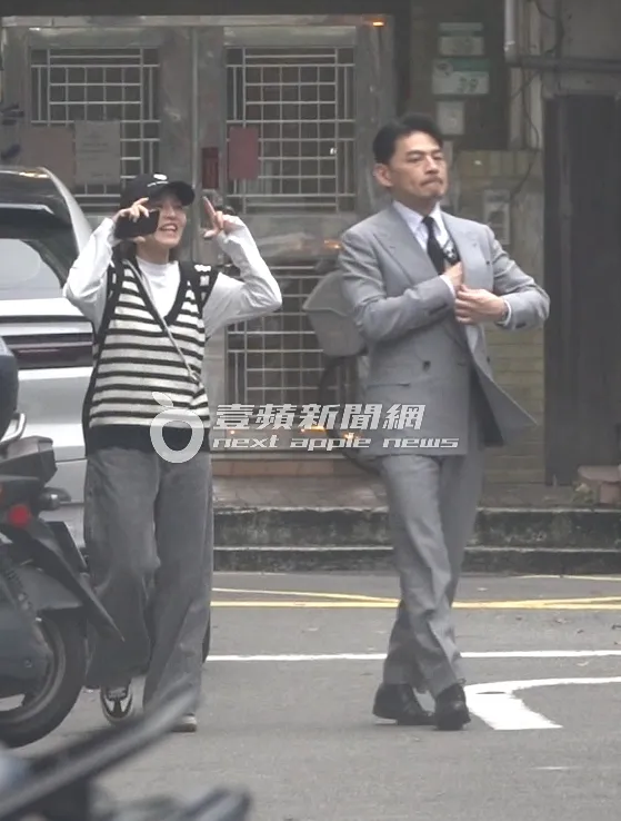 阿Ken（右）西裝筆挺，一旁美女助理手上則比著照相姿勢，看似準備拍攝工作。特勤中心攝