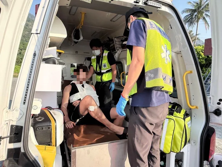 1名外籍衝浪客為了閃避野狗自摔受傷，救護人員幫他包紮。第13岸巡隊提供