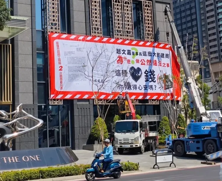 「遠雄THE ONE」被管委會高掛白布條，遠雄建設指出，目前雙方對於回饋金未達共識所致。讀者提供