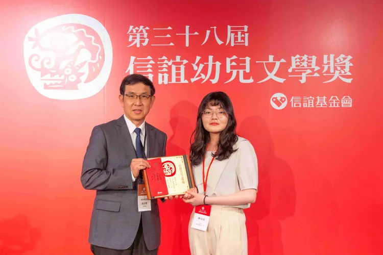 國家圖書館代理館長翁誌聰頒奬給25歲的得獎者陳冠廷。信誼基金會提供