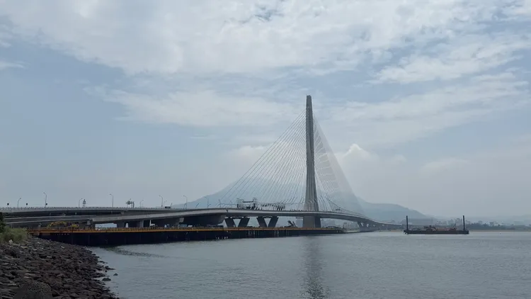 海上懸吊並精準對接66塊鋼樑節塊，拼出一座巨型鋼橋，每個節塊400噸重量有如一架波音747，猶如河口停了66架大客機。曾佳俊攝