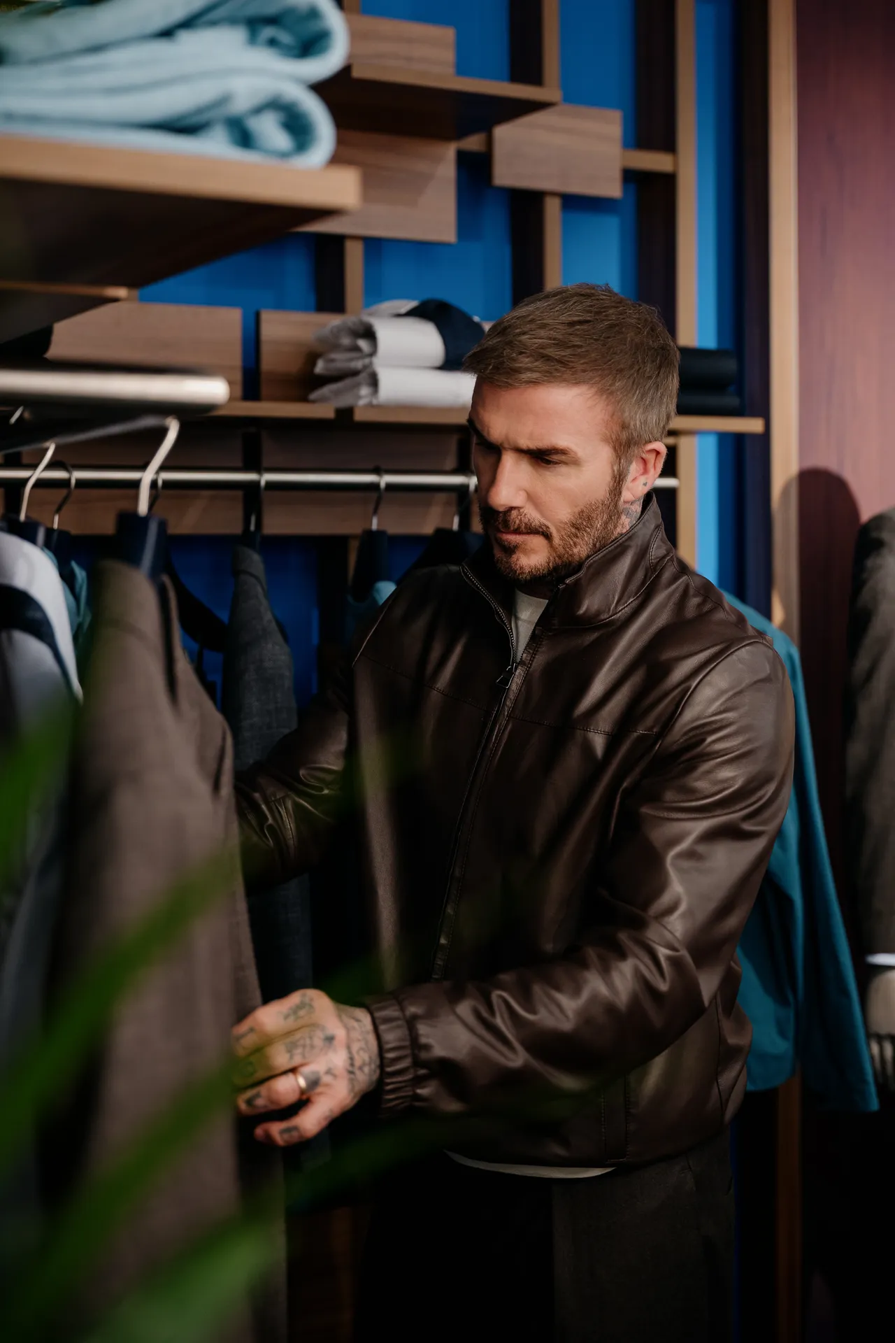 貝克漢也將棕色軟羊皮革夾克疊搭初剪羊毛短袖針織衫，休閒又俐落。品牌提供