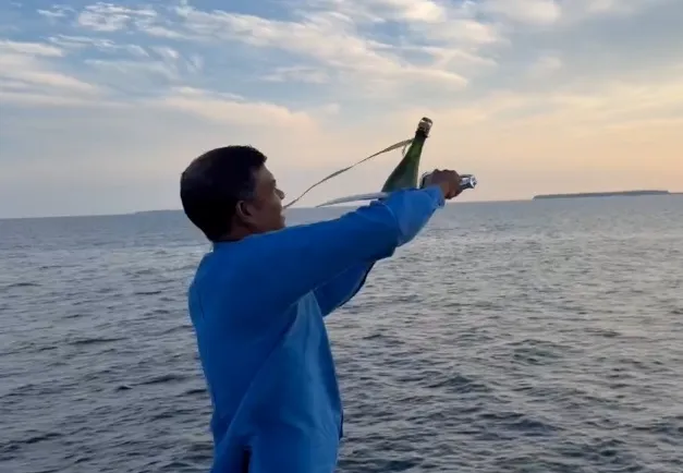 服務生對著落日海景揮劍開酒，儀式感十足。