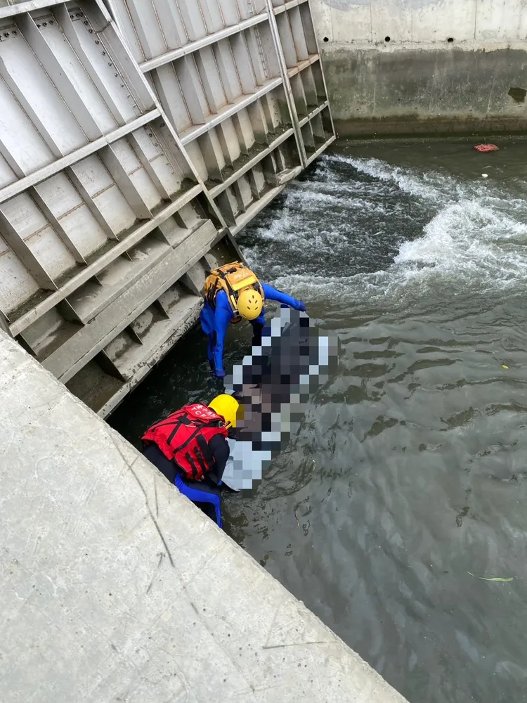 消防人員將水流屍打撈上岸，證實是失蹤5天的林姓婦人。民眾提供