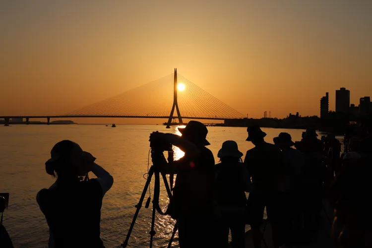 已故國際建築設計師札哈・哈蒂（Zaha Hadid）的留給世界的遺作「淡江大橋」，其減法美學產下全球最大的單塔不對稱斜張橋，完美融入淡水河口的夕照地景中，攝影愛好者卡位搶拍。莊宗達攝