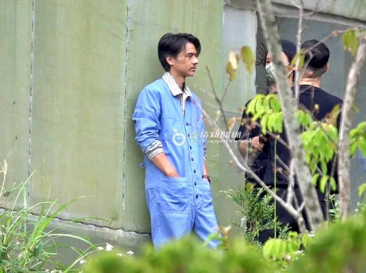 馮德倫雙手插工作服口袋，人微斜靠牆，帥氣逼人。特勤中心攝