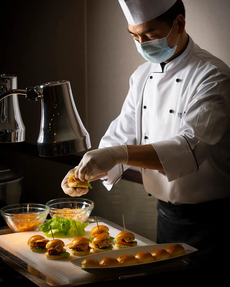 圖片01.	現點現做料理同步推出「嫩烤豬肋漢堡」，夾入鮮美肉質與蔬菜絲及酥炸洋蔥絲，呈現扎實且具互動感的飲饌體驗。台北遠東香格里拉提供