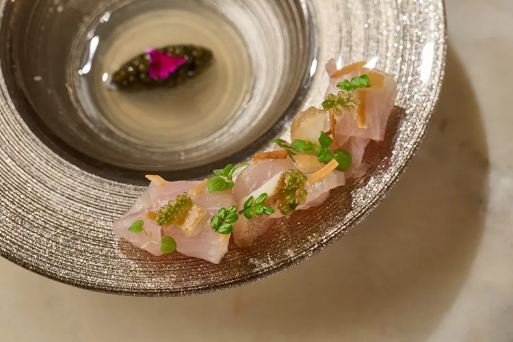 「鰤魚｜海螺｜發酵番茄」鰤魚與海螺交疊的生魚片，佐以發酵蕃茄和蛤蠣清湯製成的醬汁，兼具視覺跟味覺享受。業者提供