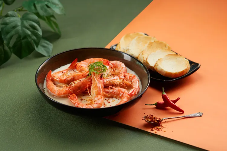 「椰汁香辣蝦」在煨煮草蝦的奶油醬裡融入辣椒、香茅、椰漿、魚露等，鮮辣中透出柔潤椰香。業者提供