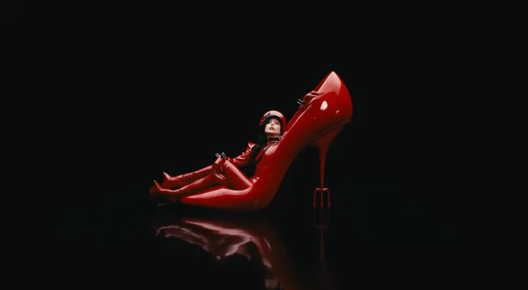 Lady Gaga換上鮮紅乳膠皮革連體衣，與電影經典元素紅色高跟鞋同框。翻攝Lady Gaga YouTube