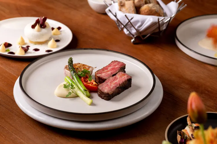 「原木炭烤美國極佳級牛小排」以高溫直火鎖住肉汁，油脂均勻分布，呈現濃郁風味。台北慕軒飯店，臻品之選提供