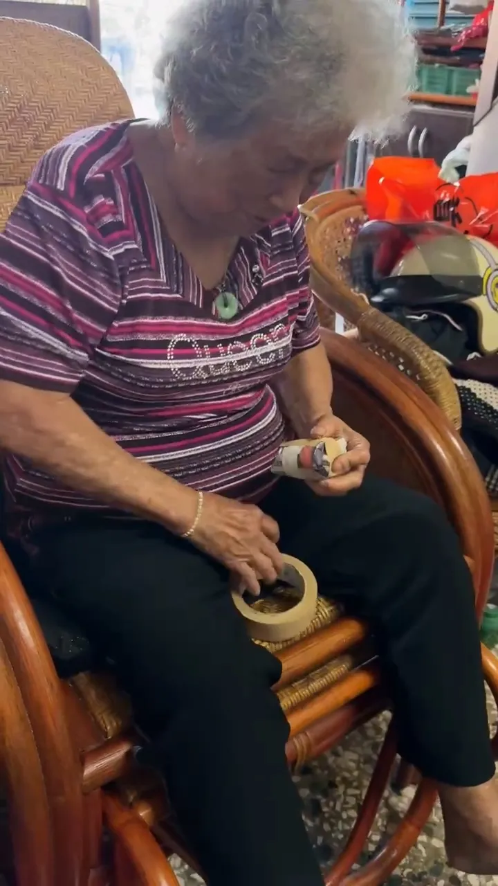 鄭金枝示範以報紙與膠帶製作「報紙球」，作為日常練習投球工具。大港阿媽孫女提供