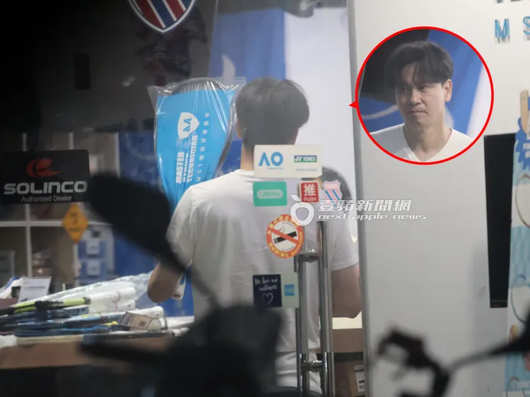 李聖傑在網球用品專賣店挑選網球拍，拿起球拍試手感。特勤中心攝